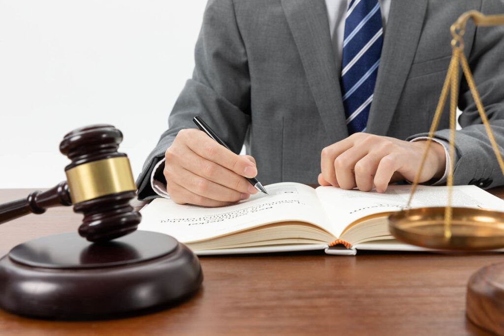 Can I sue for defamation? - closeup shot of a person writing in a book with a gavel on the table